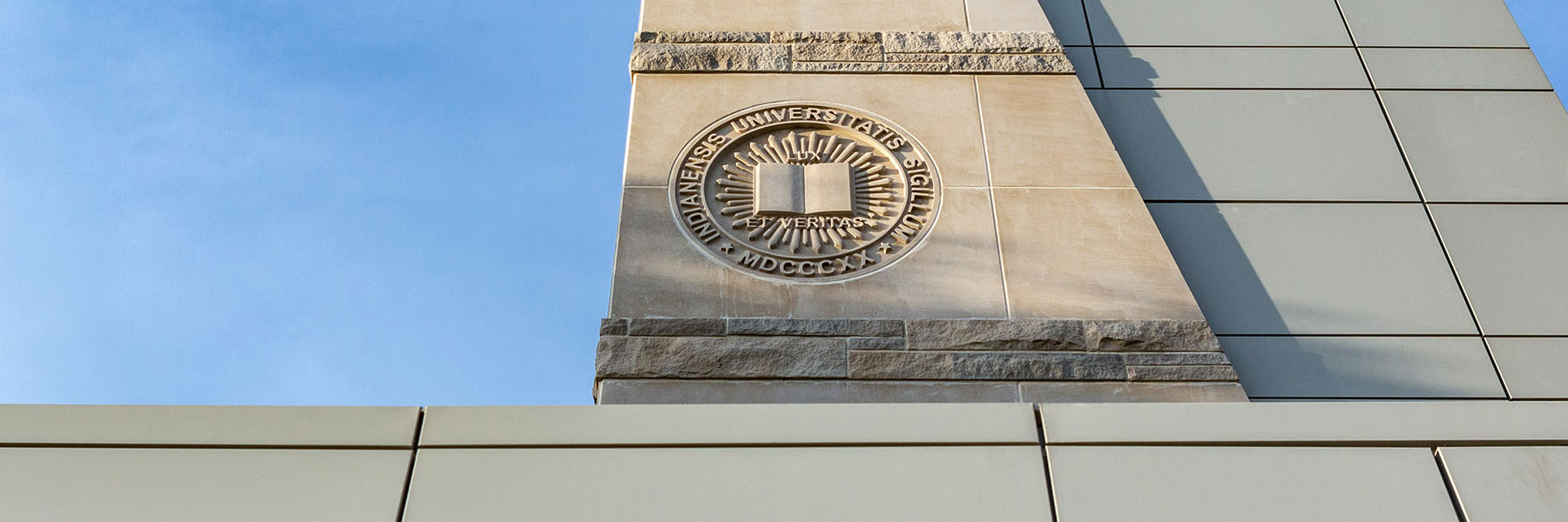 The Indiana University seal on a limestone building.